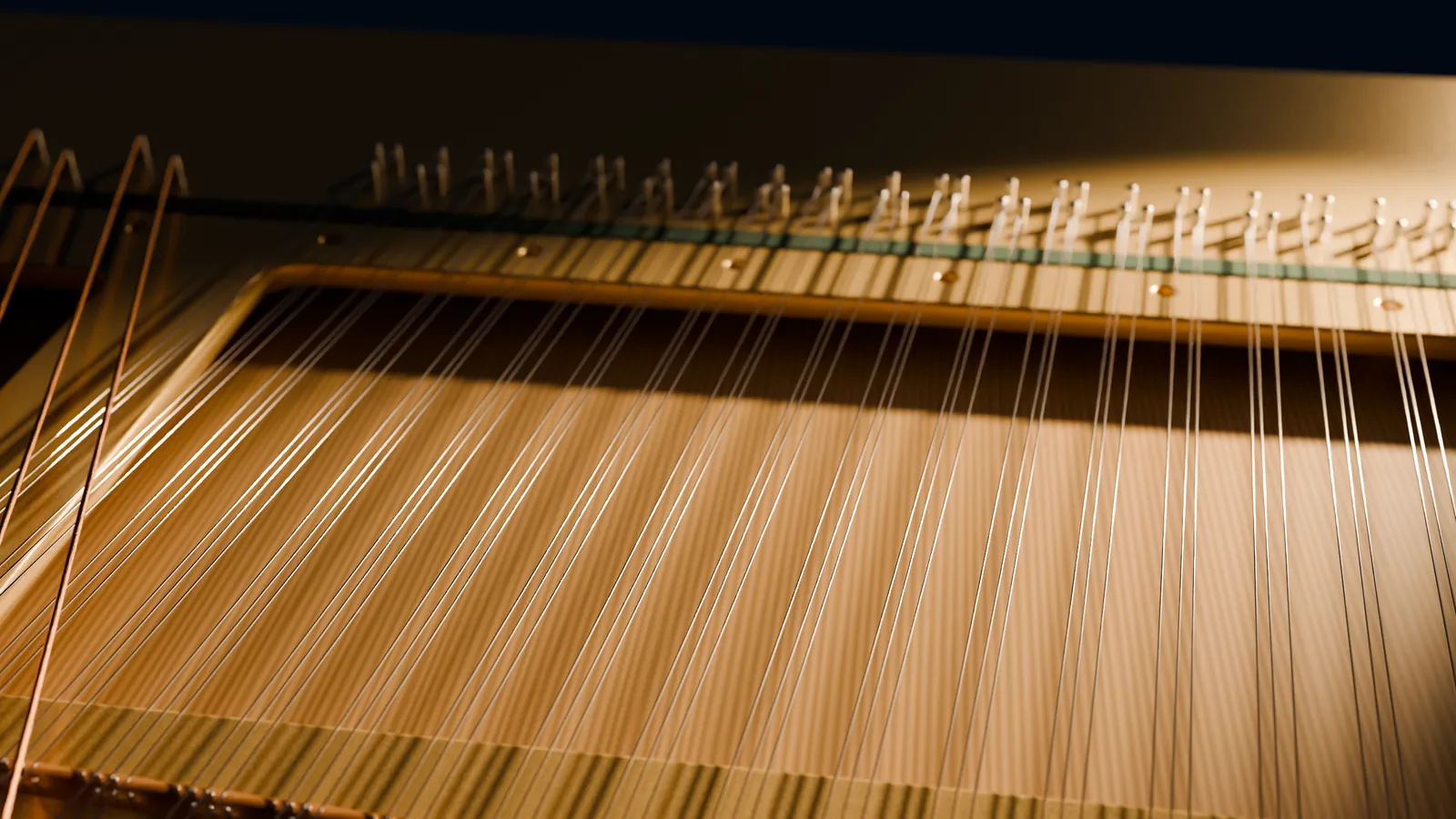 Inside a piano in low golden light: steel strings in threes running up to their tuning pins, copper bass strings crossing them
